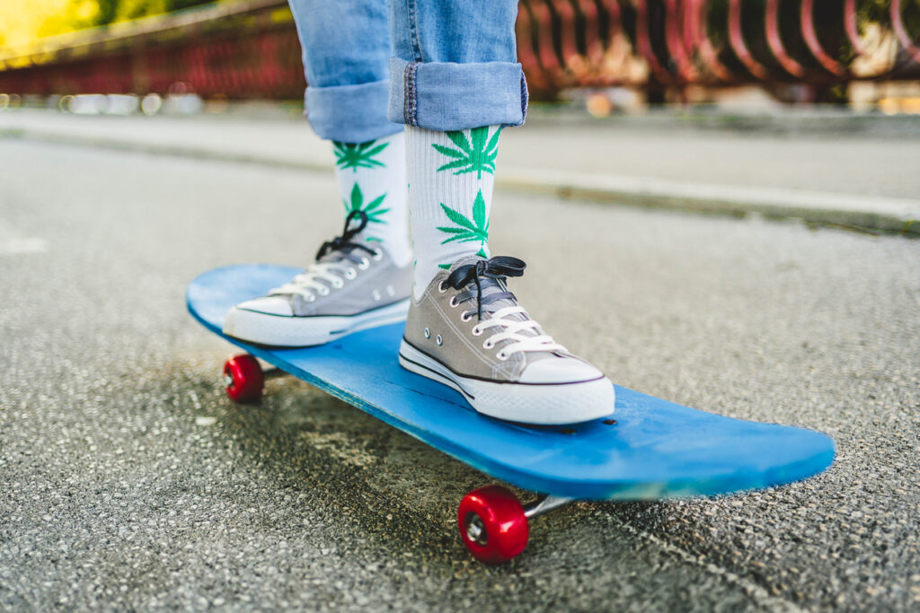 Jeune skateur portant des chaussettes cannabis