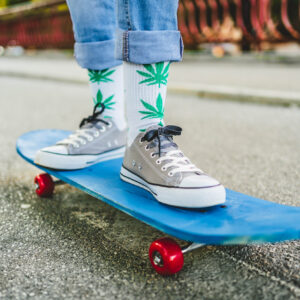 Jeune skateur portant des chaussettes cannabis