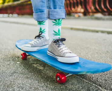 Jeune skateur portant des chaussettes cannabis