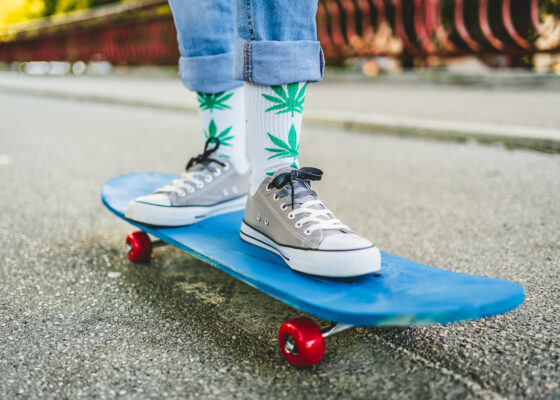 Jeune skateur portant des chaussettes cannabis