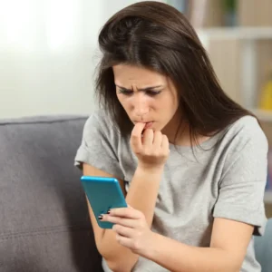 Jeune femme inquiète devant son smartphone