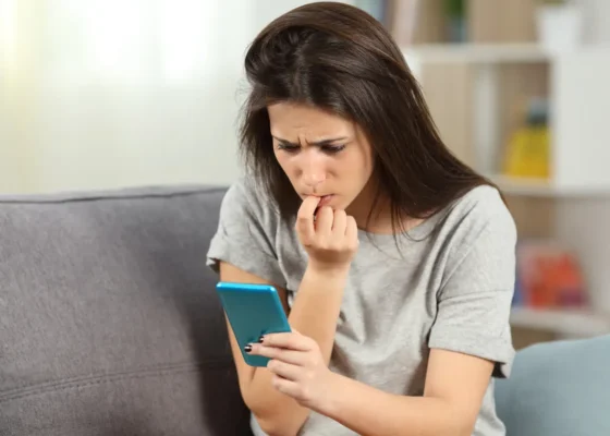 Jeune femme inquiète devant son smartphone