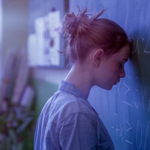 Teenager girl in math class overwhelmed by the math formula. Pressure, Education, Success concept.